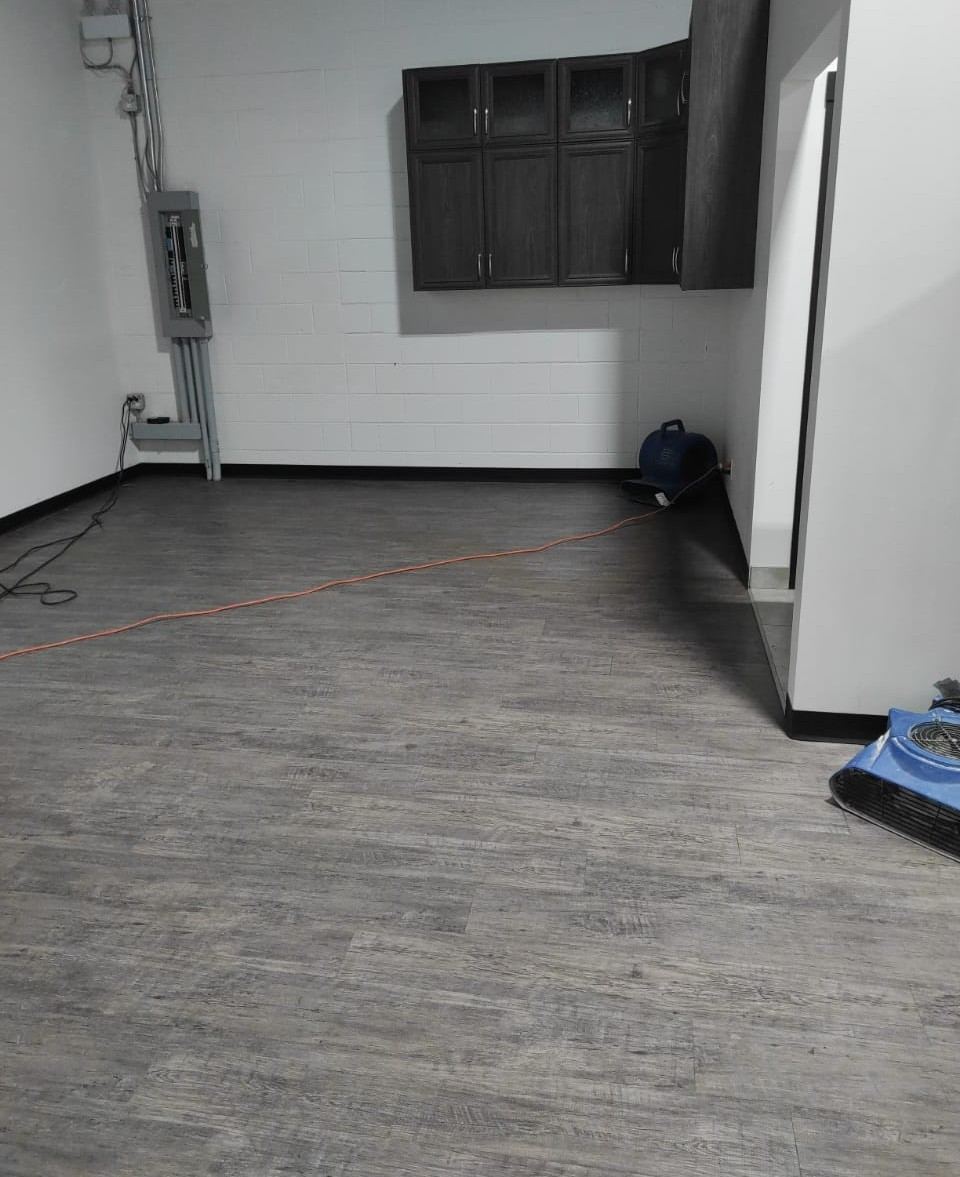 Restored commercial space with new vinyl plank flooring installed after water damage repairs
